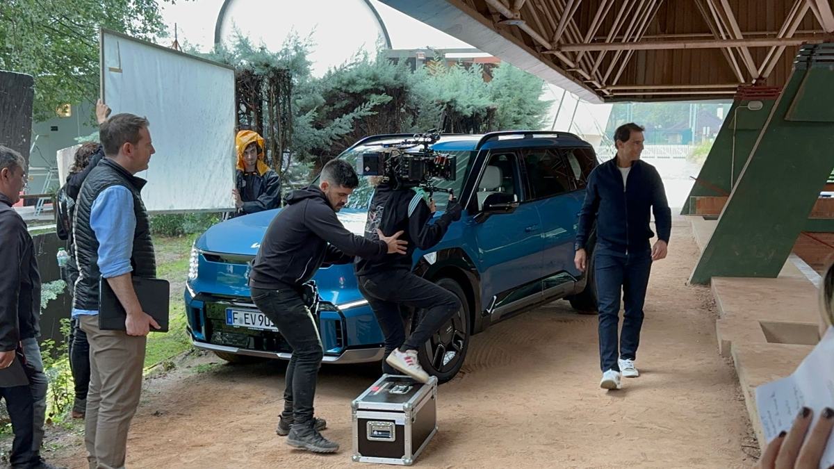 The crew filming beside the car as Rafael Nadal walks past